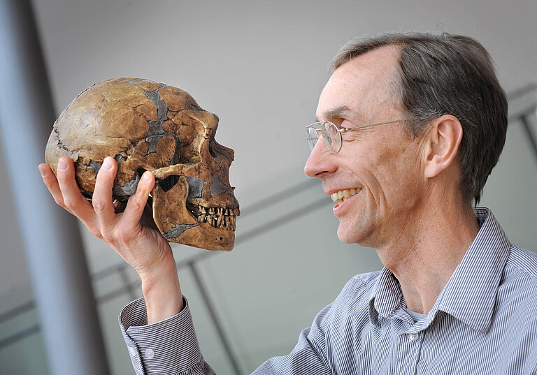 Svante Pääbo holding the skull of a Neandertal.